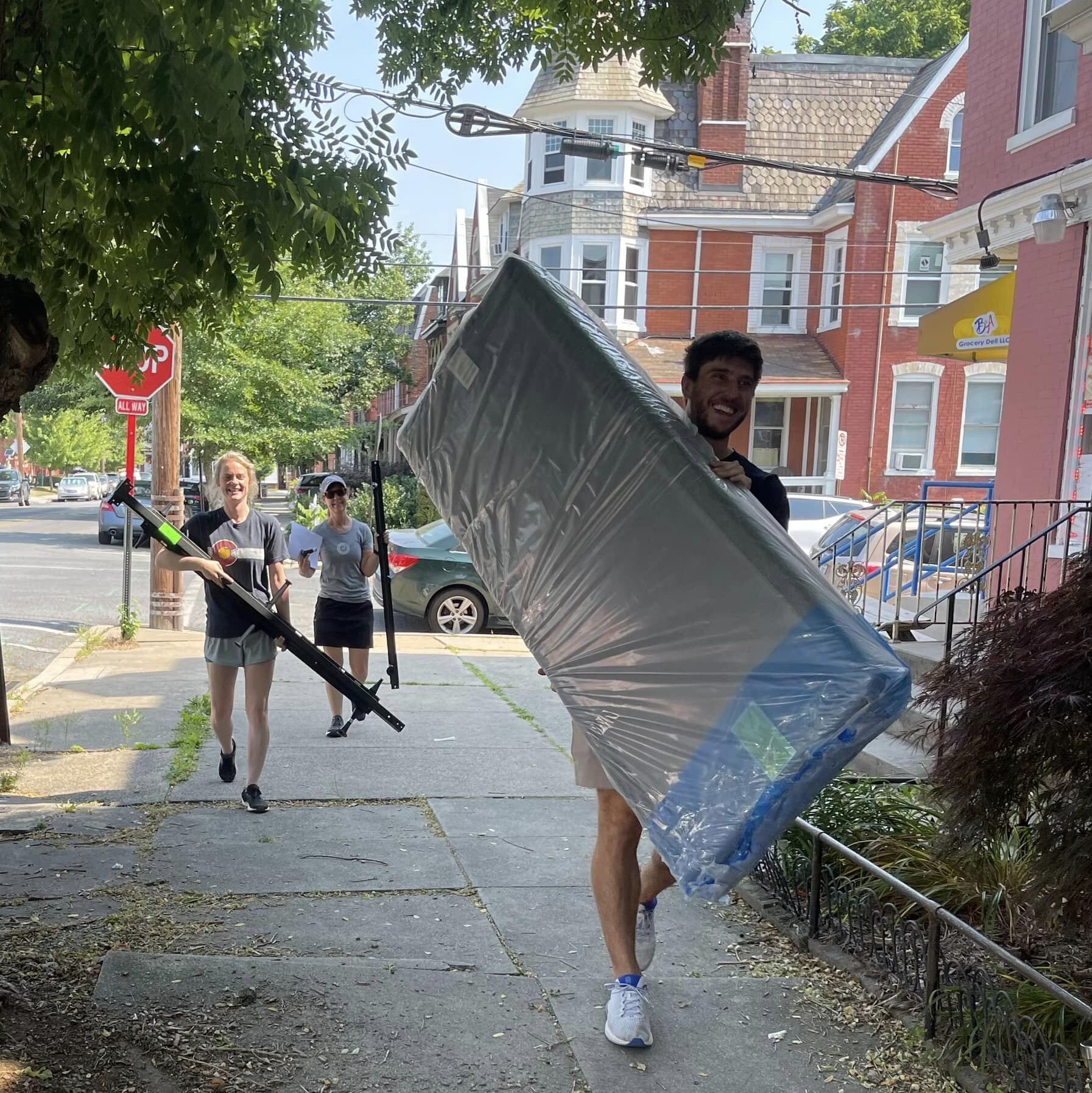 volunteer carrying bed